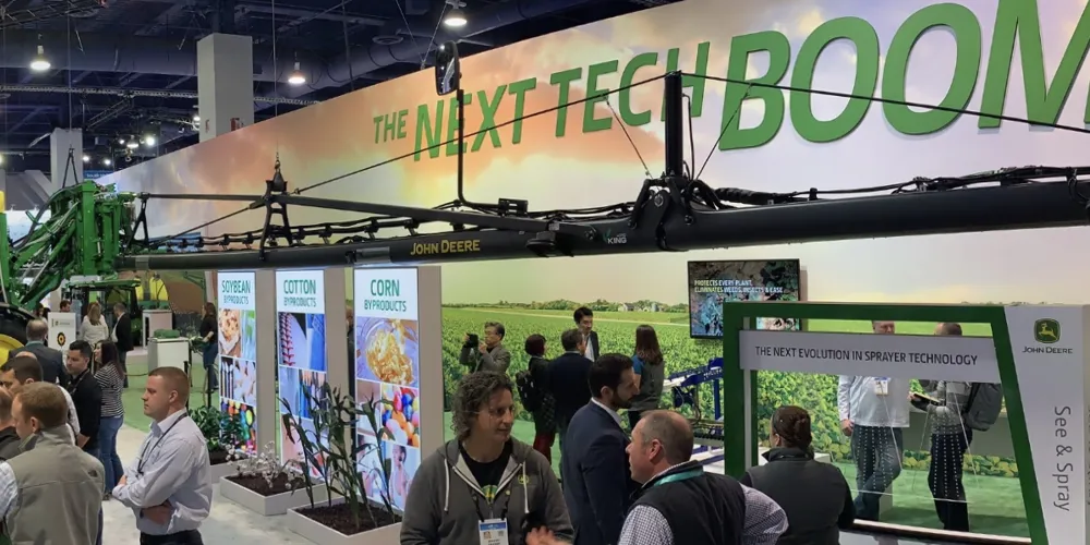 ALT Text: a panoramic view of John Deere's booth at CES with the banner saying the next tech BOOM